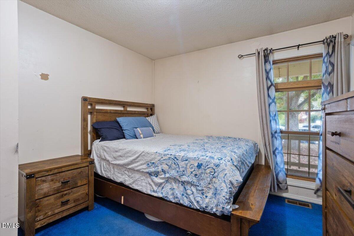 1600 Cranston Road Garner, NC 27529 - Photo 15 of 25 a bedroom with a bed a dresser and wooden floor
