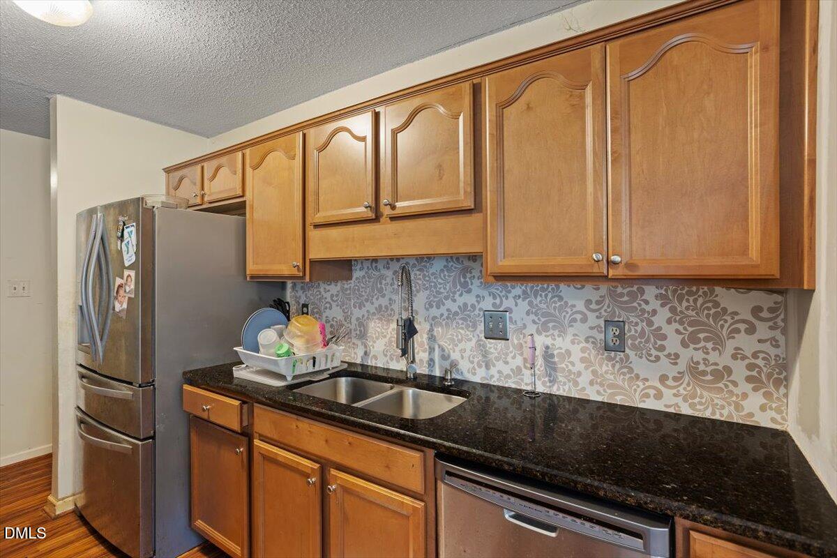 1600 Cranston Road Garner, NC 27529 - Photo 24 of 25 a kitchen with stainless steel appliances granite countertop a refrigerator sink and stove