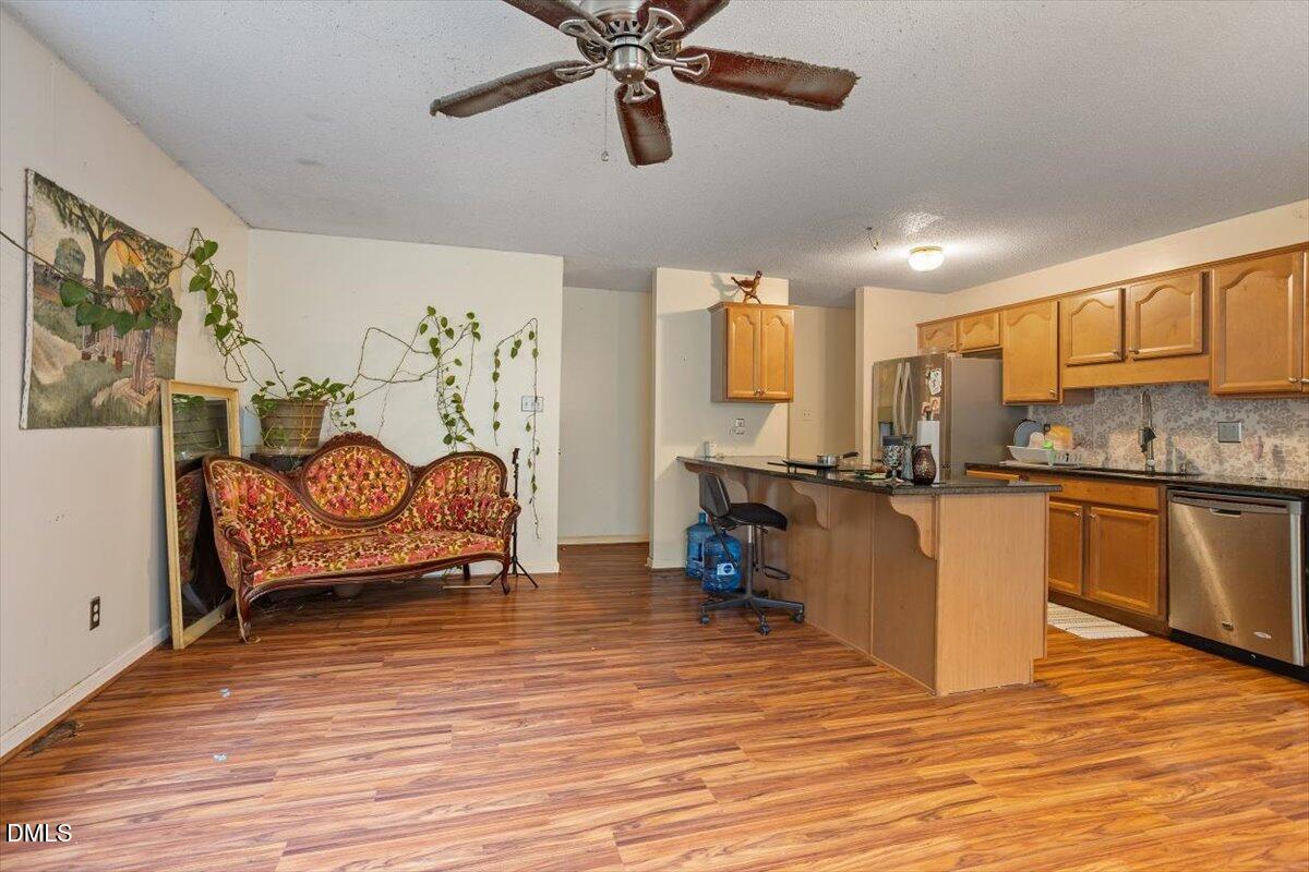 1600 Cranston Road Garner, NC 27529 - Photo 8 of 25 a kitchen with stainless steel appliances granite countertop a stove top oven a chimney cabinets and wooden floor