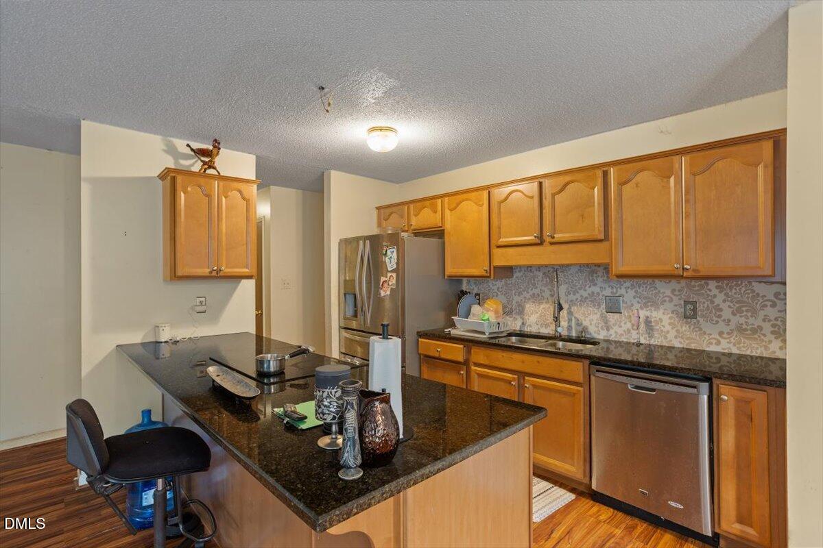 1600 Cranston Road Garner, NC 27529 - Photo 10 of 25 a kitchen with stainless steel appliances granite countertop a sink stove and cabinets