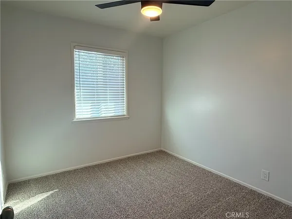 an empty room with closet and a chandelier fan