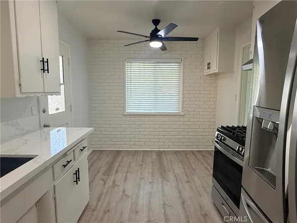 a kitchen with wooden floors and stainless steel appliances