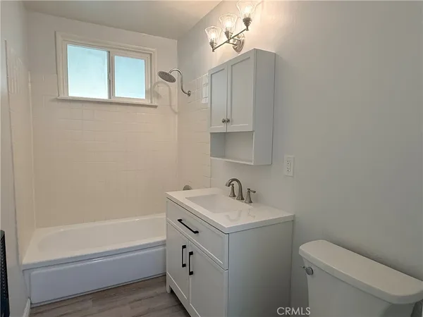 a bath room with a toilet a sink and a bath tub