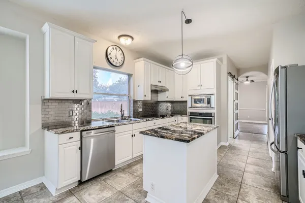 a kitchen with refrigerator cabinets and stainless steel appliances