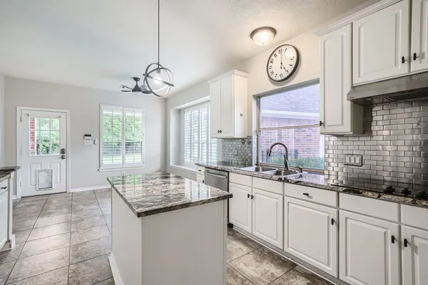 a kitchen with cabinets and chandelier