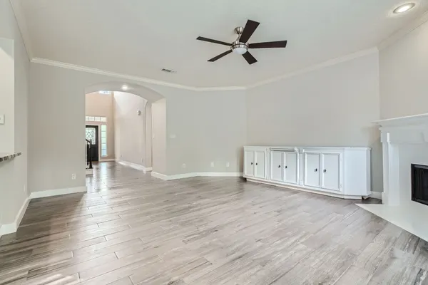 a view of a livingroom with wooden floor and a ceiling fan
