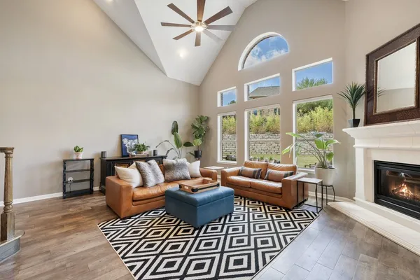 a living room with furniture a fireplace and a large window