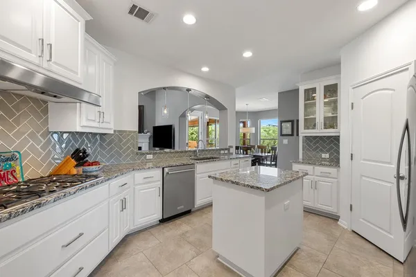 a kitchen with stainless steel appliances granite countertop a sink stove and refrigerator