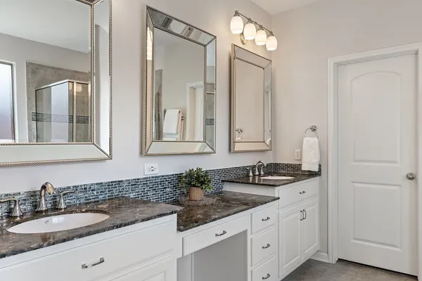 a bathroom with double sink and a mirror