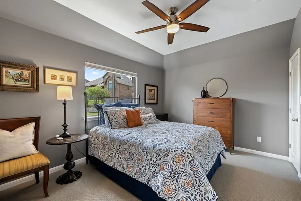 a bedroom with a bed dresser and a chair