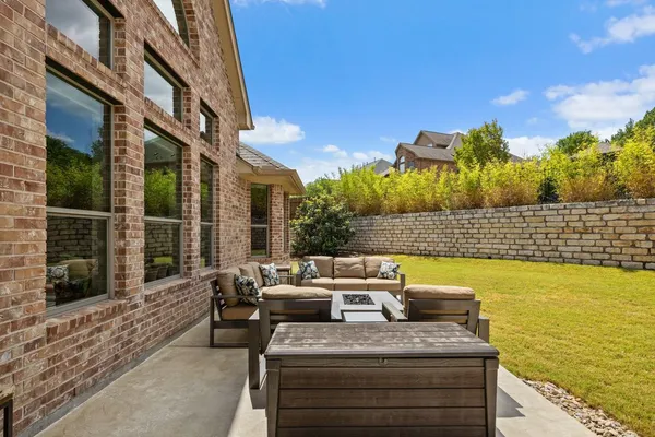 a view of a patio with couches chairs potted plants and ocean view