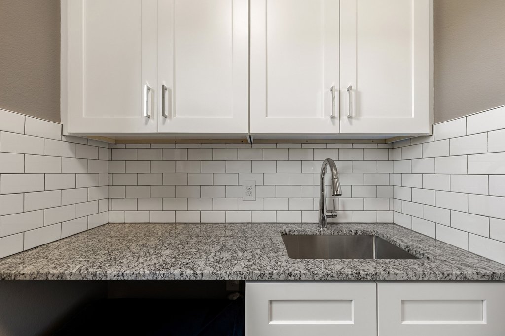 12333 Labrador Bay Court Austin, TX 78732 - Photo 39 of 40 a kitchen with granite countertop white cabinets and a sink