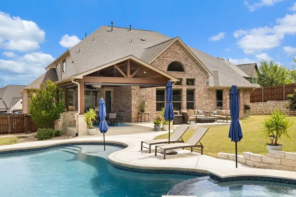 a view of a house with swimming pool and sitting area