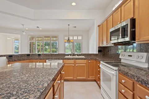 a kitchen with granite countertop a sink and a stove