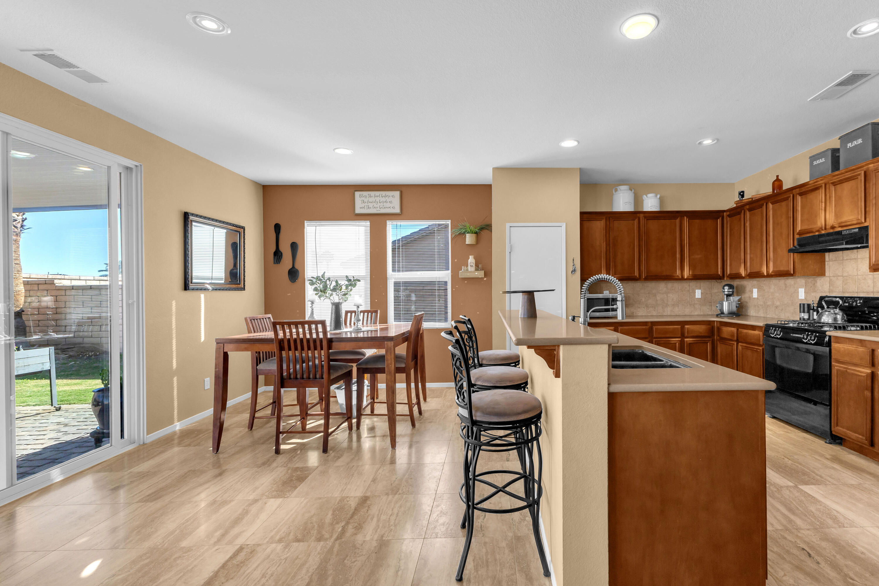 41394 Hanover Street Indio, CA 92203 - Photo 10 of 49 a kitchen with stainless steel appliances granite countertop sink refrigerator dining table and chairs