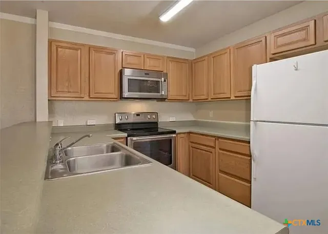 a kitchen with a refrigerator sink and microwave