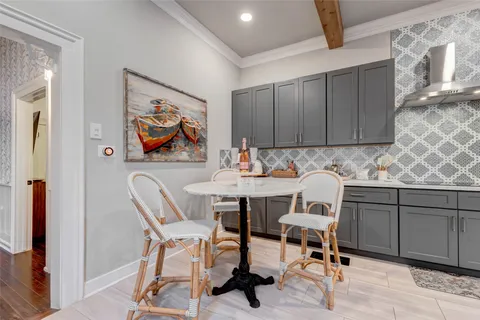 a kitchen with stainless steel appliances granite countertop a stove a sink a dining table and chairs