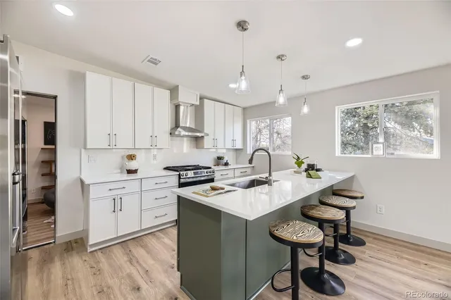 a kitchen with stainless steel appliances granite countertop a stove refrigerator sink and cabinets