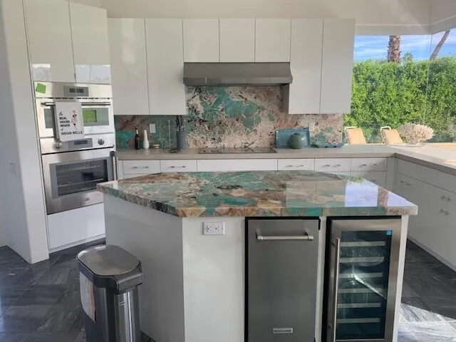 a kitchen with stainless steel appliances granite countertop a stove a sink and a refrigerator