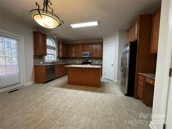 a kitchen with stainless steel appliances granite countertop a stove a refrigerator and a sink