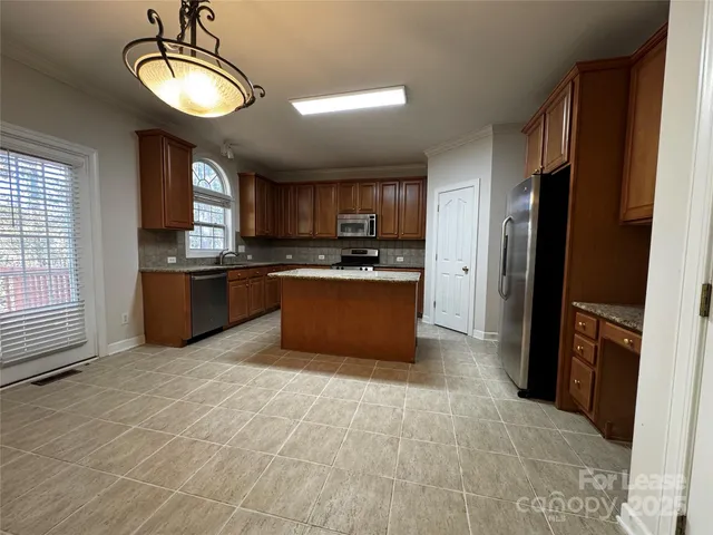 a kitchen with stainless steel appliances granite countertop a stove a refrigerator and a sink