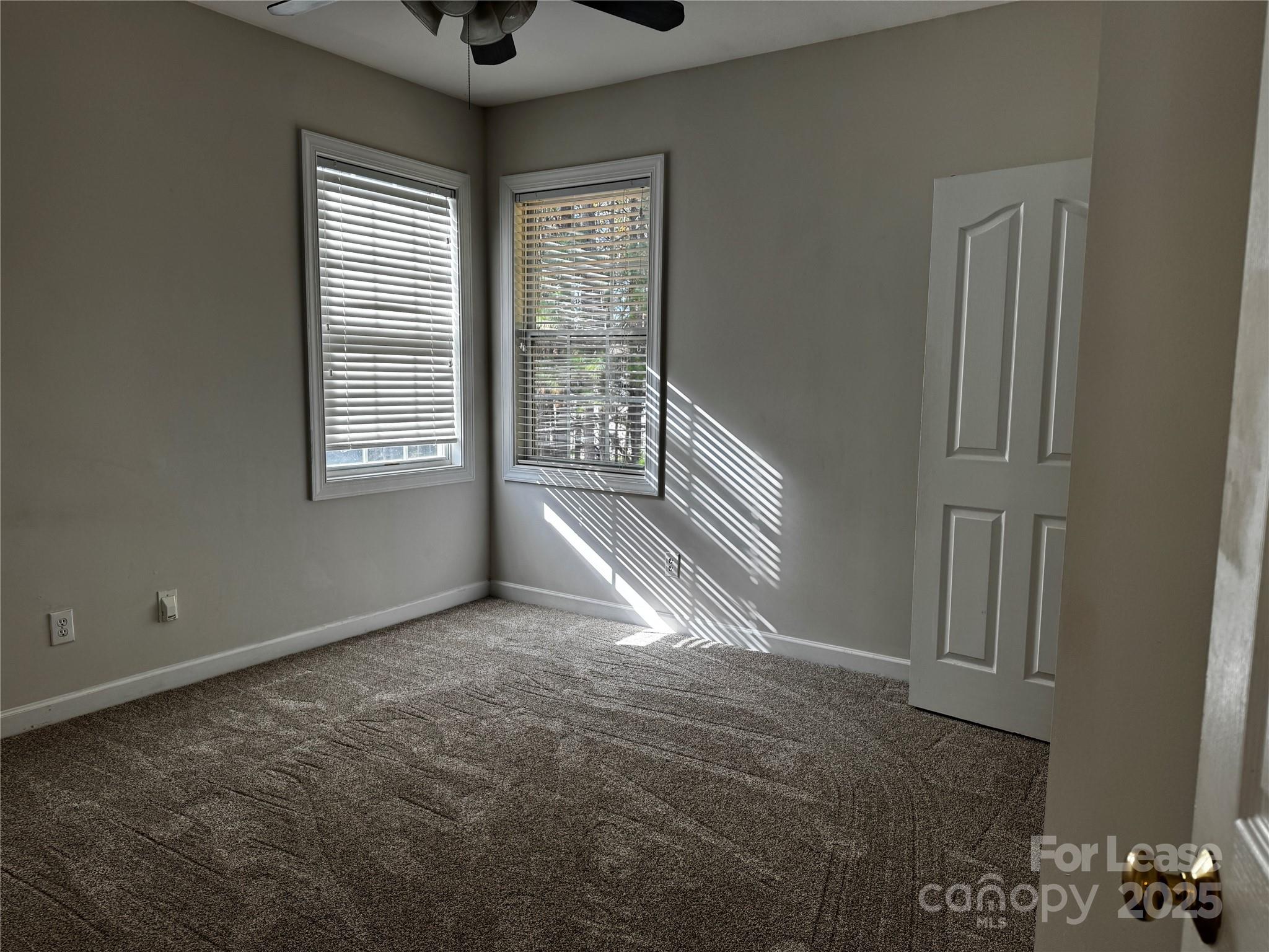 15628 Sullivan Ridge Drive Charlotte, NC 28277 - Photo 22 of 29 an empty room with windows and chandelier fan