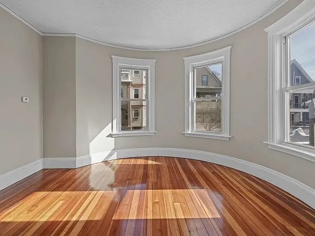 a view of a room with wooden floor and windows
