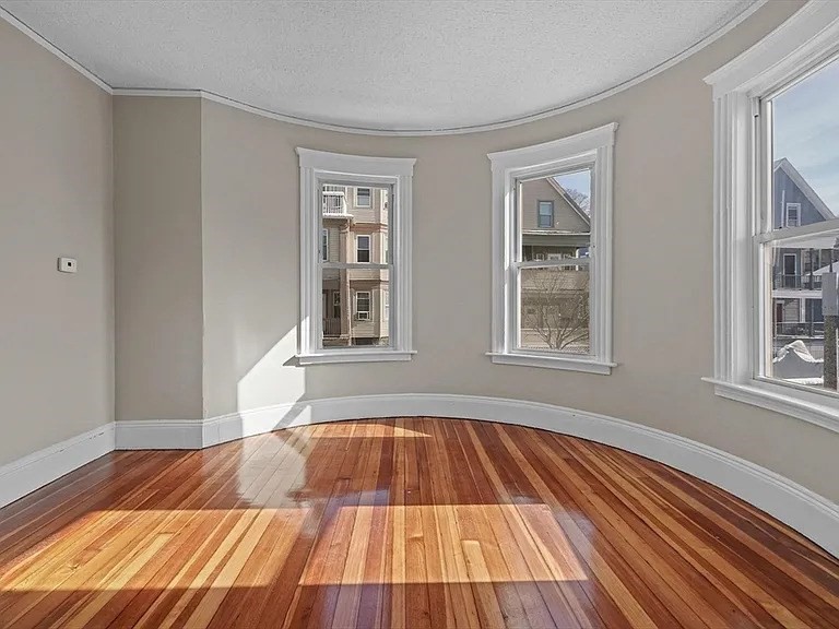 205 Hamilton Street, Unit 3 Boston, MA 02122 - Photo 6 of 9 a view of a room with wooden floor and windows