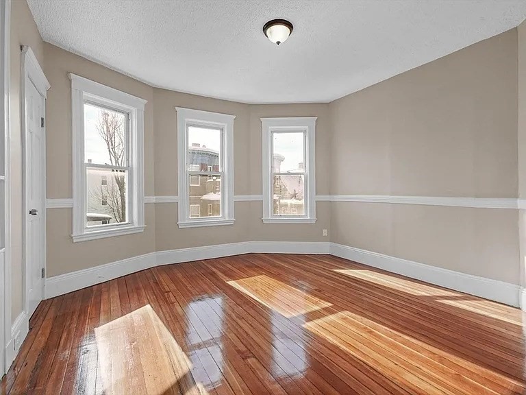 205 Hamilton Street, Unit 3 Boston, MA 02122 - Photo 7 of 9 a view of an empty room with wooden floor and a window