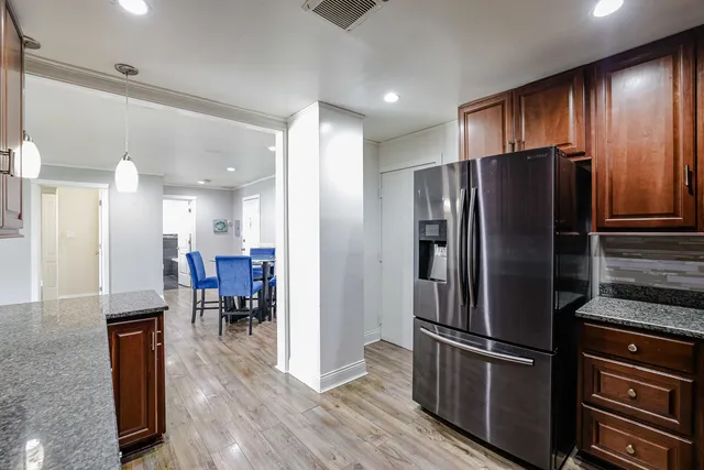 a kitchen with stainless steel appliances granite countertop wooden cabinets a stove top oven a sink and dishwasher