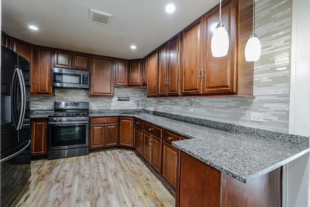 a kitchen with stainless steel appliances granite countertop a sink stove and refrigerator