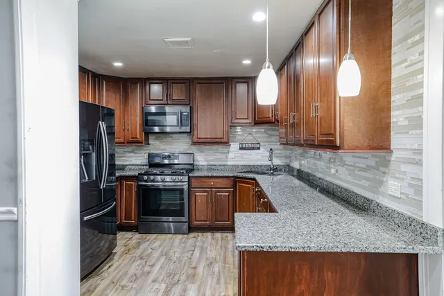 a view of a dining room with furniture a chandelier and wooden floor