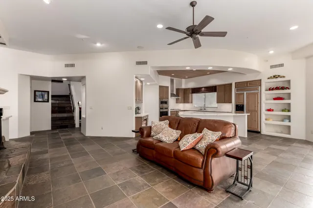 a large white kitchen with stainless steel appliances granite countertop a stove a sink dishwasher and a black refrigerator