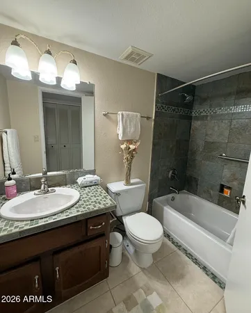 a bathroom with a granite countertop sink mirror vanity and toilet