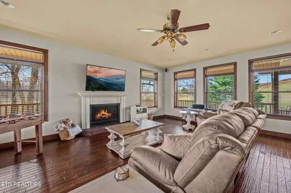 a living room with fireplace furniture and a large window