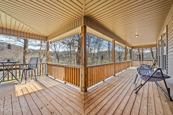 a balcony with wooden floor table and chairs