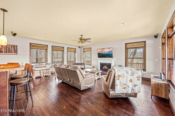 a living room with furniture kitchen view and a large window