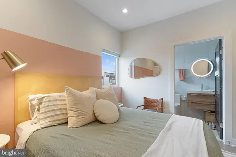 a bedroom with a bed and painting on the wall
