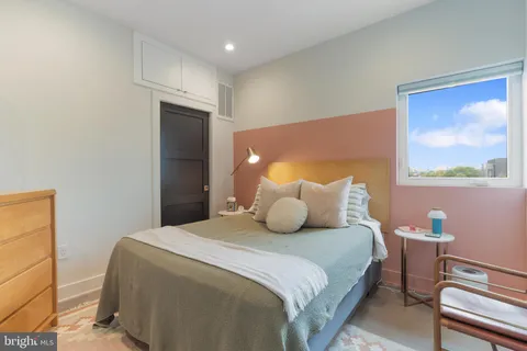 a bedroom with a bed and a painting on the wall