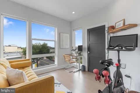 a living room with furniture a flat screen tv and a floor to ceiling window