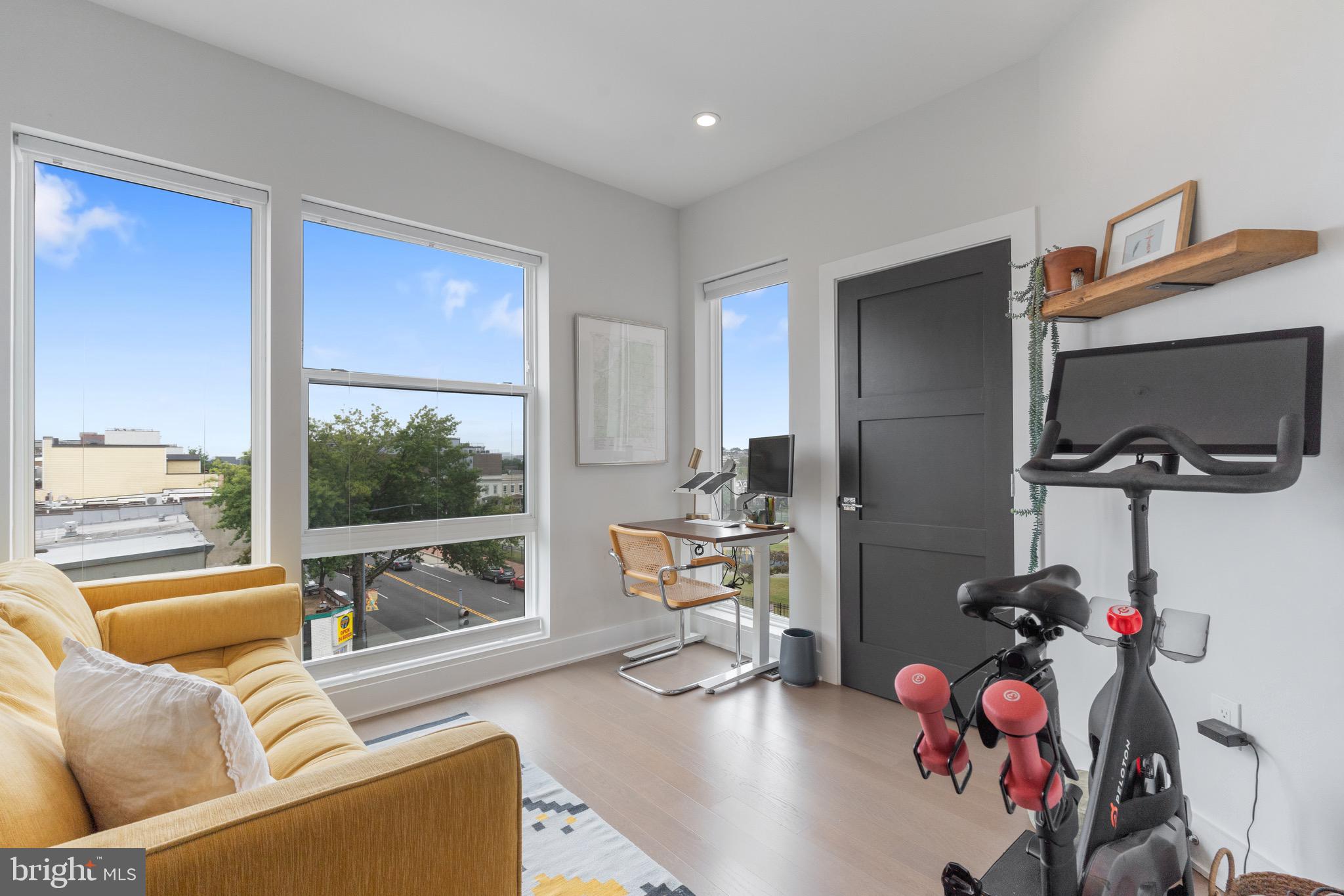 653 Irving Street Northwest, Unit 7 Washington, DC 20010 - Photo 20 of 31 a living room with furniture a flat screen tv and a floor to ceiling window
