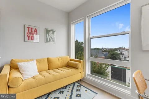 a living room with furniture and a floor to ceiling window