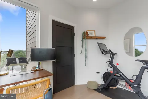 a view of a workspace with furniture and gym equipment