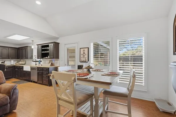 a dining room with stainless steel appliances a dining table and chairs