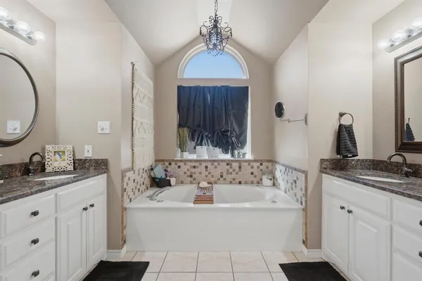 a bathroom with a tub sink and mirror
