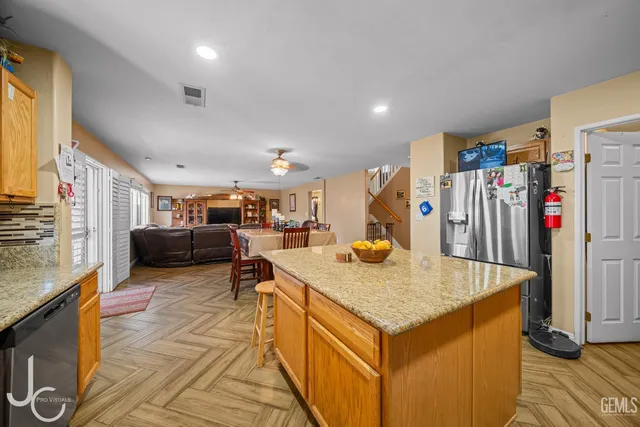 a view of kitchen center island sink stove and refrigerator