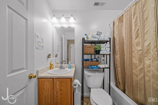 a bathroom with a sink a toilet and shower curtain