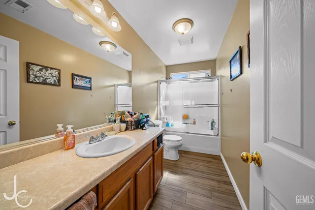 a bathroom with a sink double vanity granite and a toilet