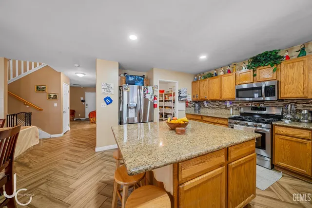 a kitchen with stainless steel appliances granite countertop a sink a stove and cabinets