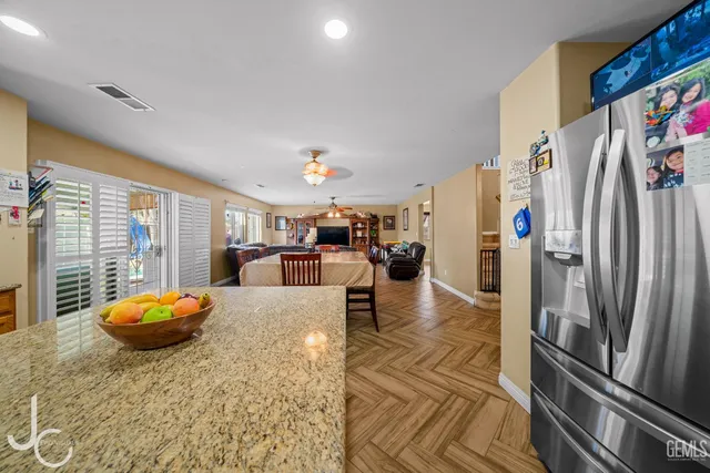 a kitchen with stainless steel appliances granite countertop a refrigerator a stove and a sink